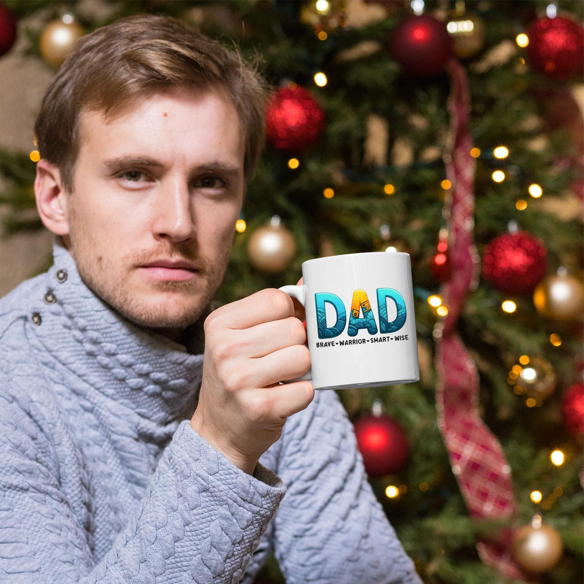 Man holding the DAD Brave Warrior mug in front of a Christmas tree