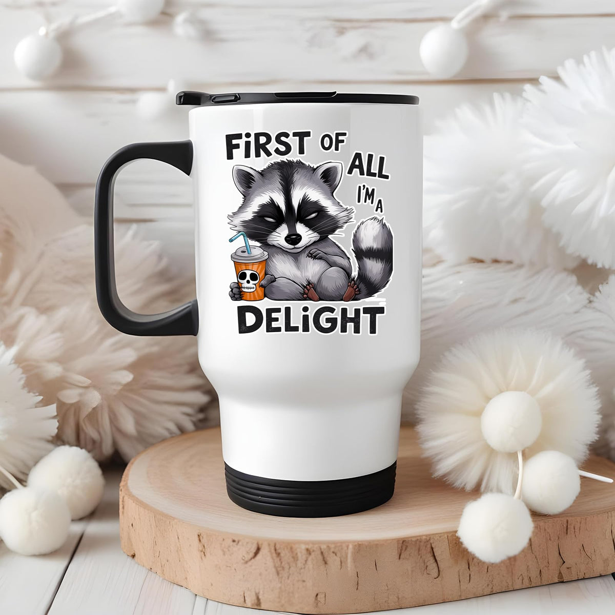 First of All I’m a Delight raccoon travel mug on a wooden slice with white pom-poms