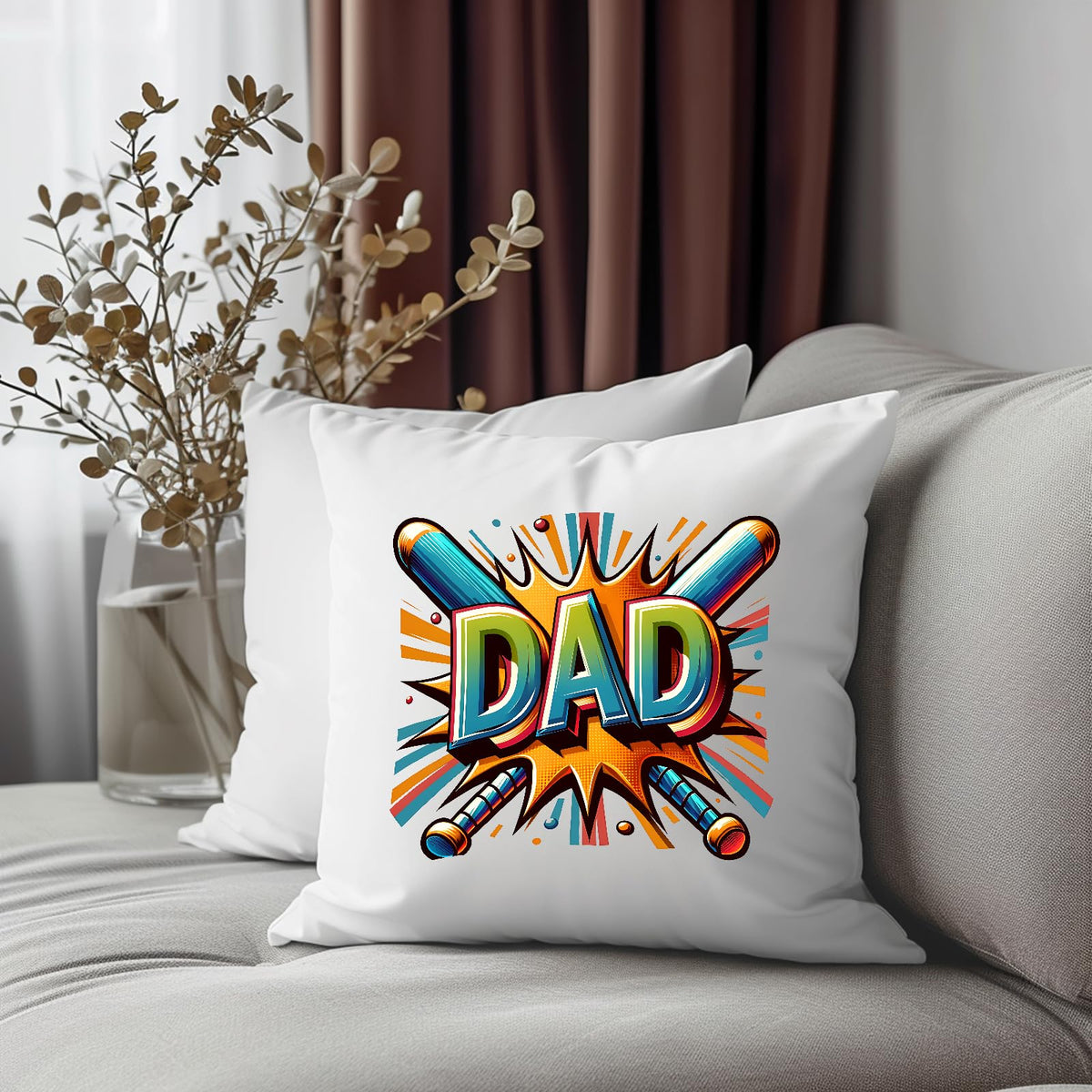 DAD baseball bats cushion on a grey sofa beside dried flowers