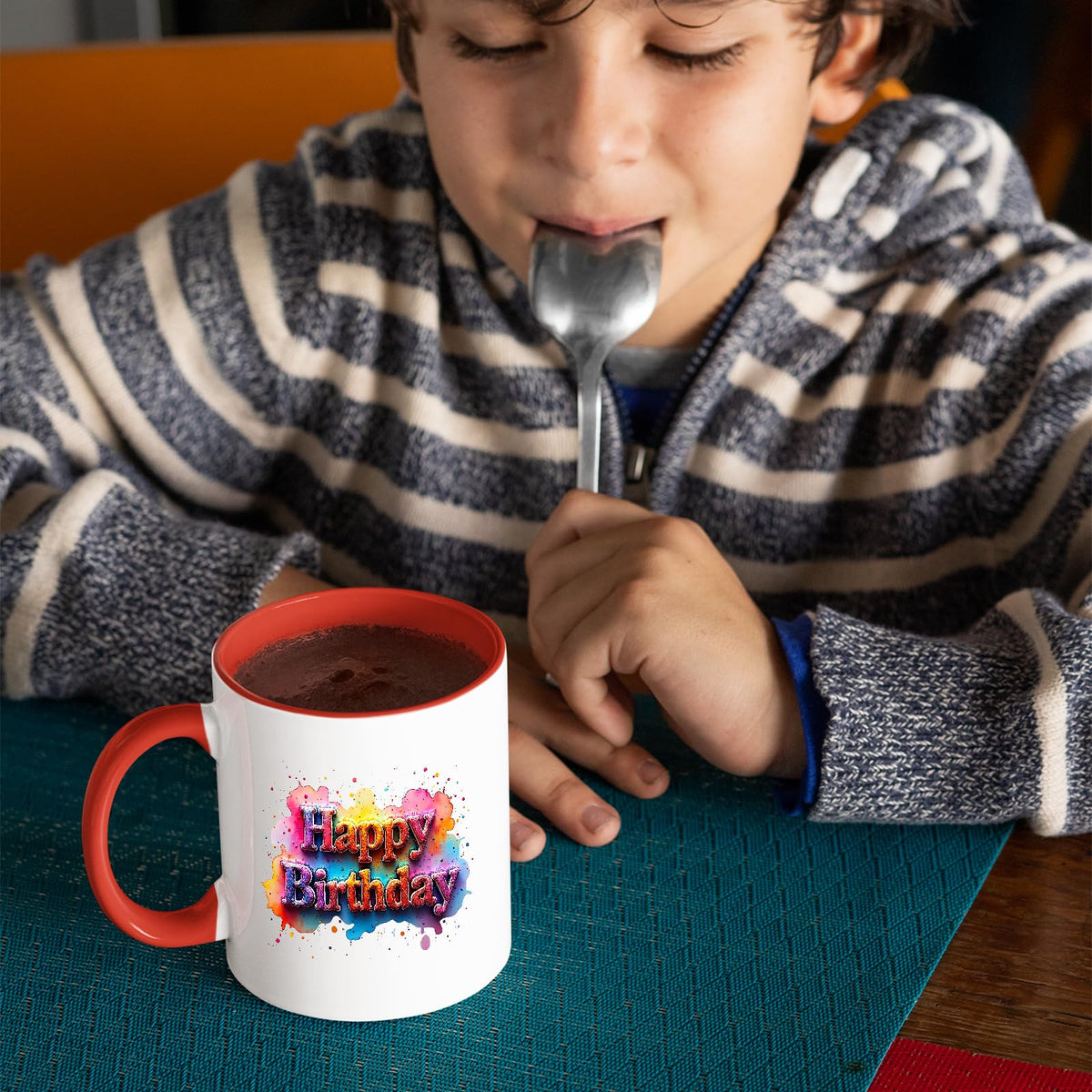 Child drinking from the mug with a red handle