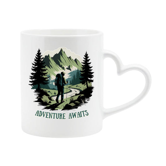 White heart-handle mug with a hiker on a mountain trail between pine trees with “Adventure awaits”