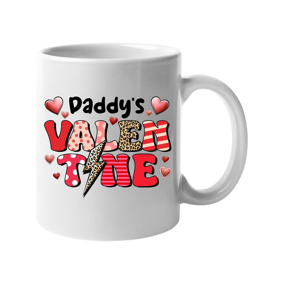 White mug with “Daddy’s Valentine” in patterned letters with hearts and a leopard lightning bolt