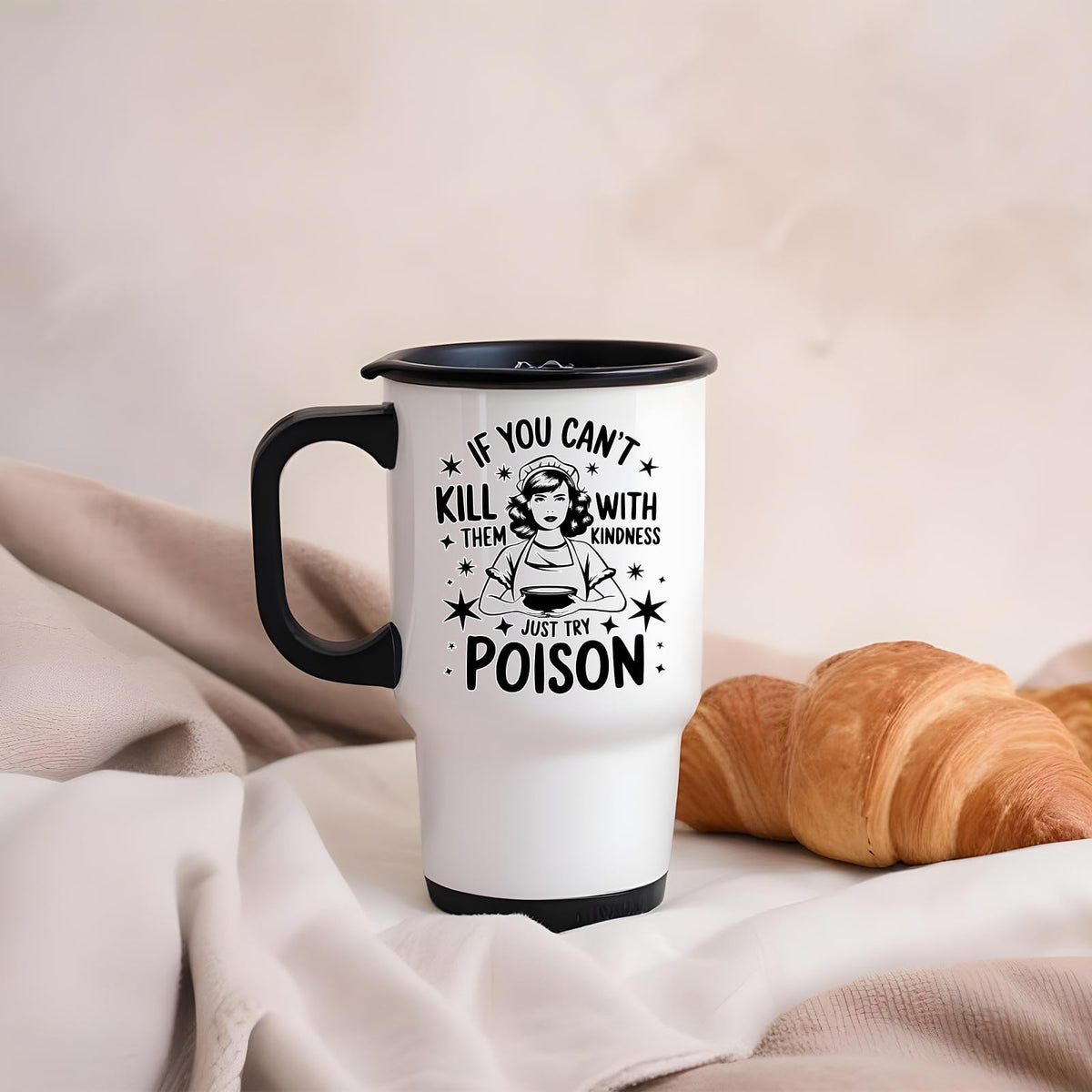 Just Try Poison travel mug on a soft blanket beside a croissant