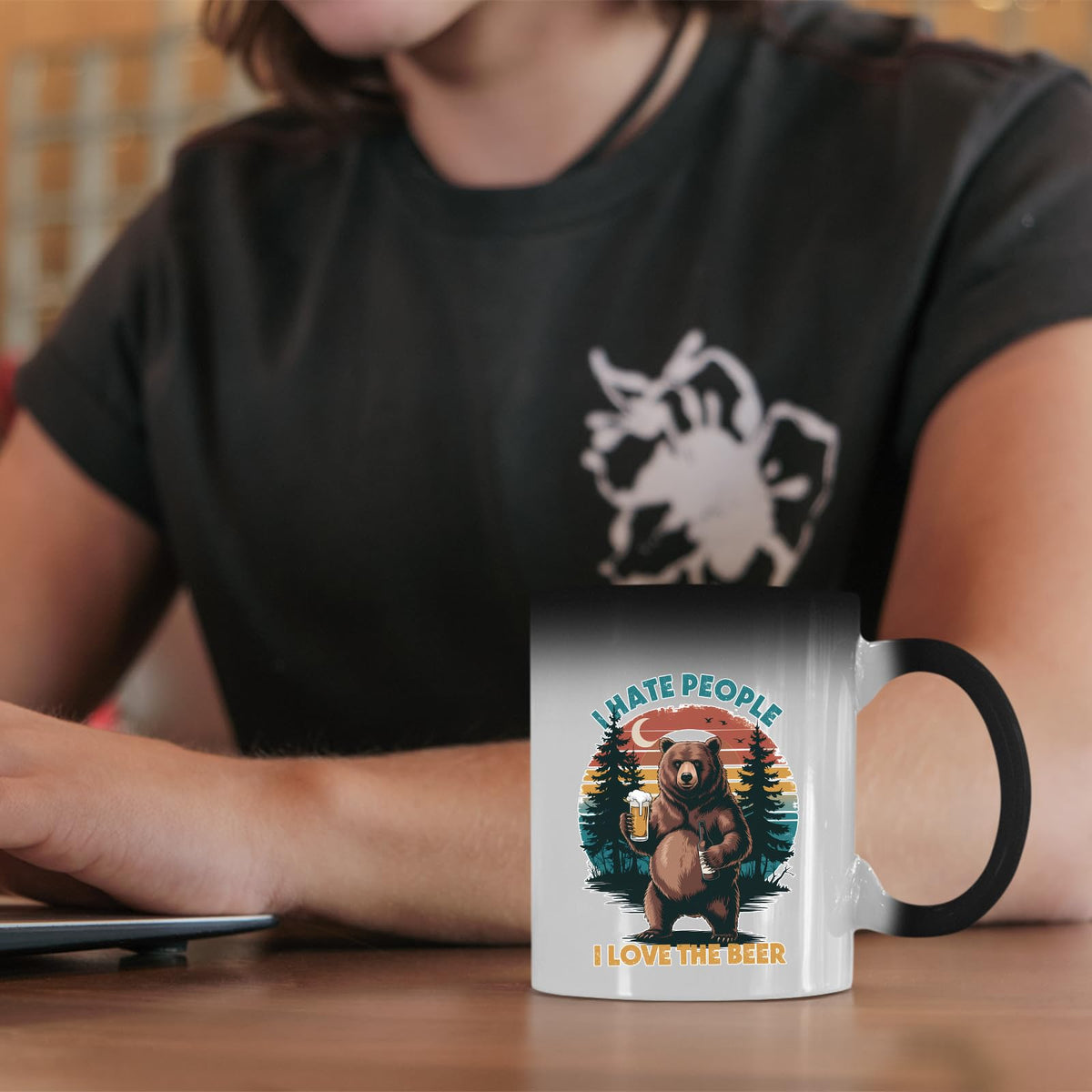 beer-loving bear colour changing mug on a desk beside a laptop