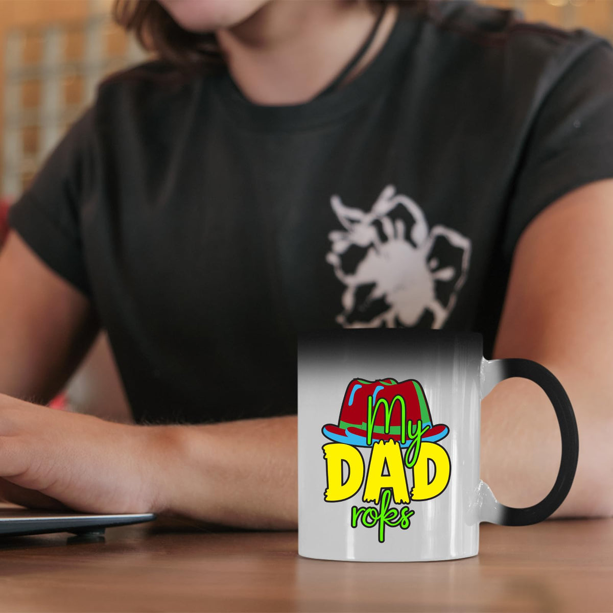 Colour changing mug with the colourful My Dad Rocks hat design on a desk