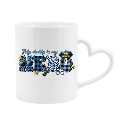White heart-handle mug with “My daddy is my hero” in blue plaid and leopard letters with a police cap and badge