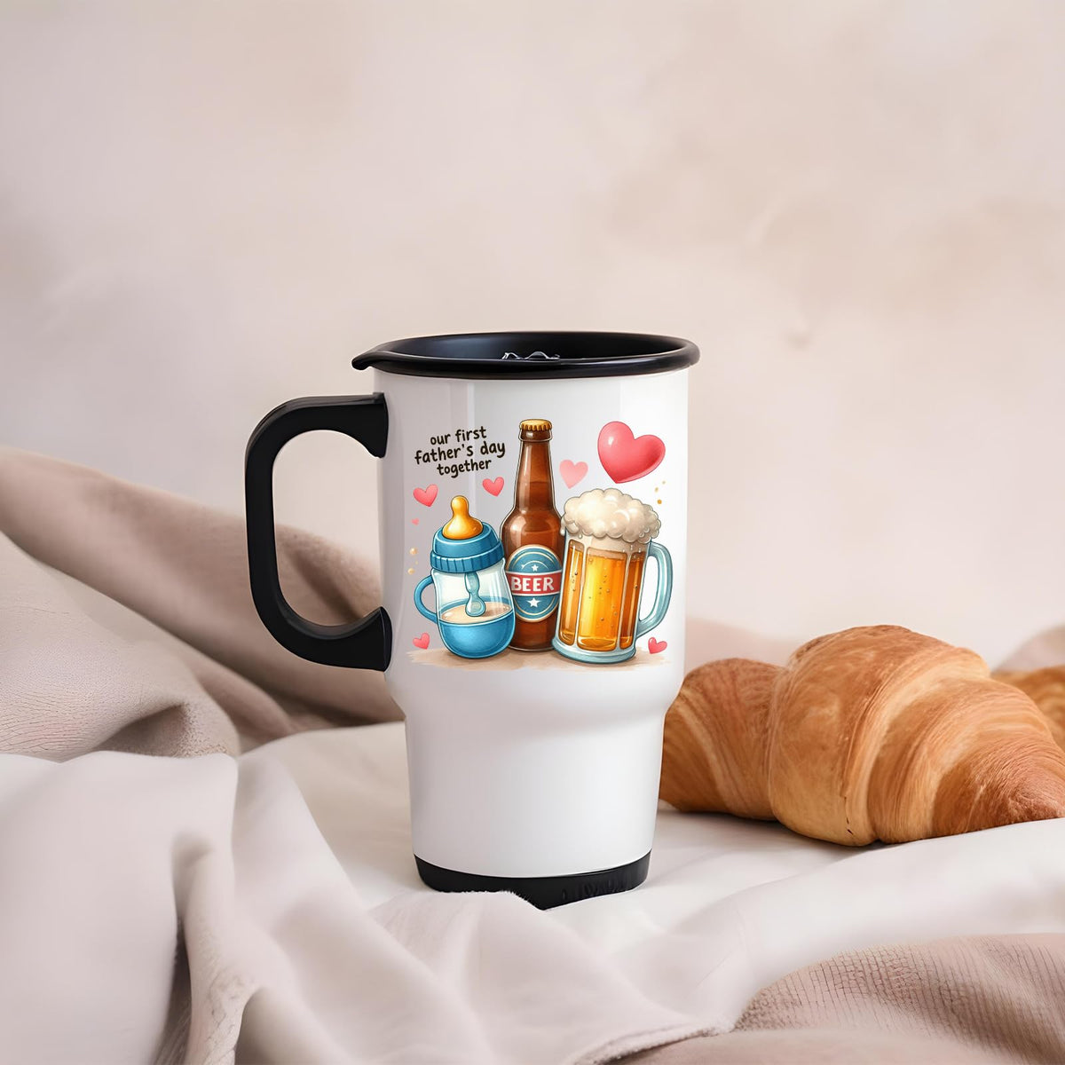 First Father’s Day hearts travel mug on a soft blanket beside a croissant