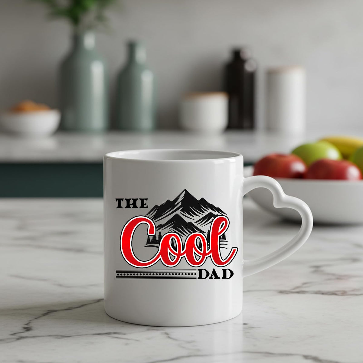 The Cool Dad mountains heart-handle mug on a marble counter with fruit