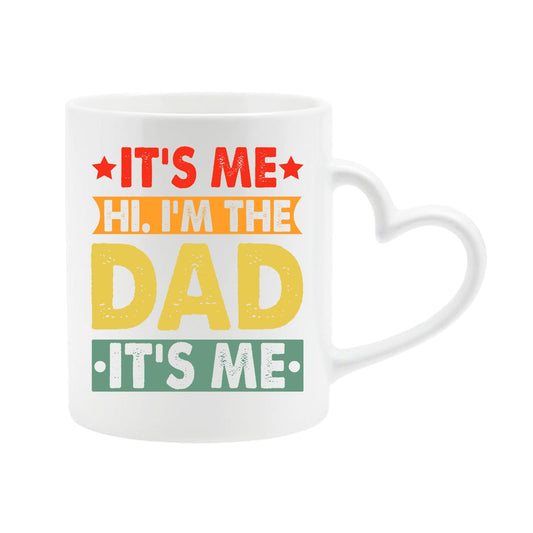 White heart-handle mug with “It’s me, hi, I’m the dad, it’s me” in retro coloured banners