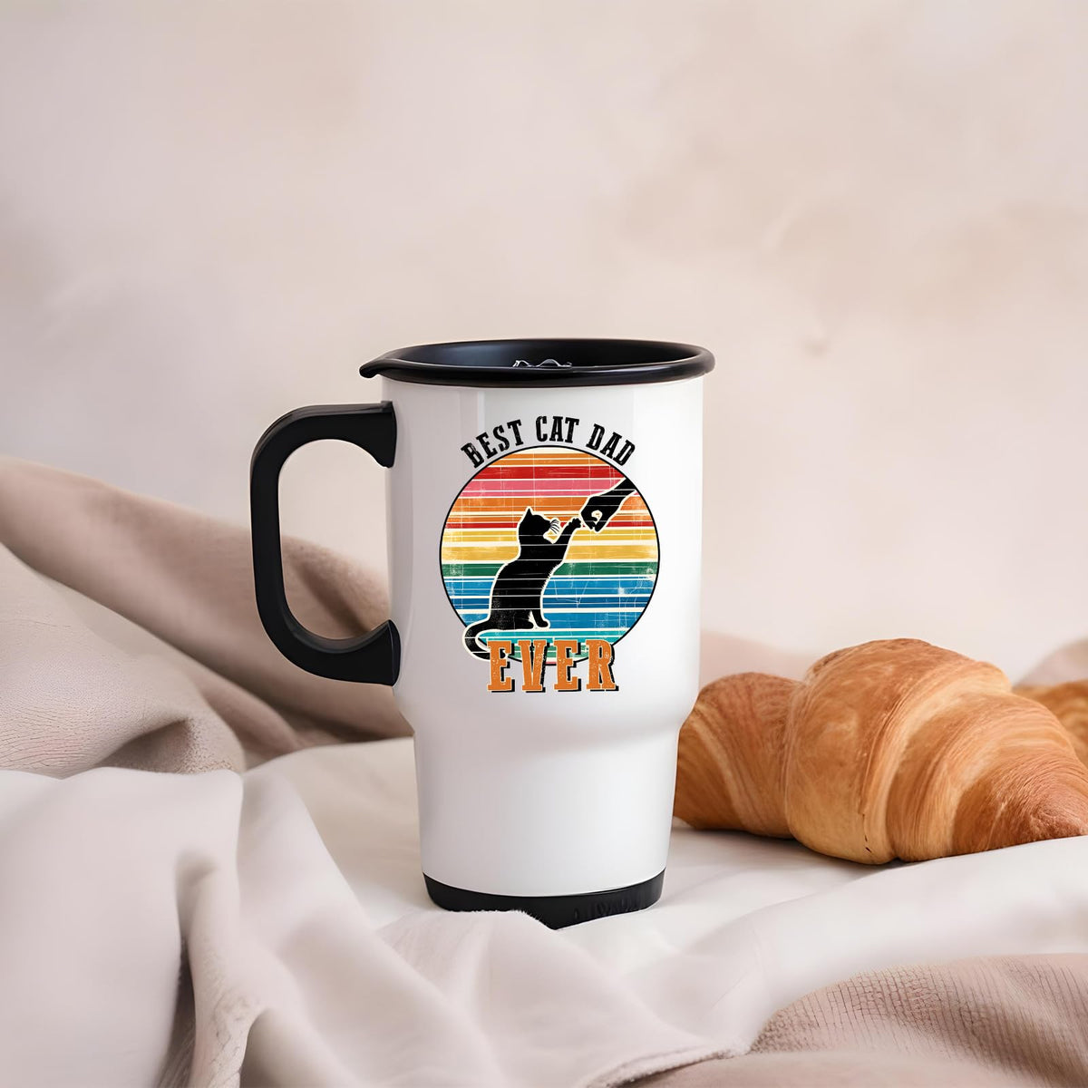 Best Cat Dad Ever travel mug on a soft blanket beside a croissant