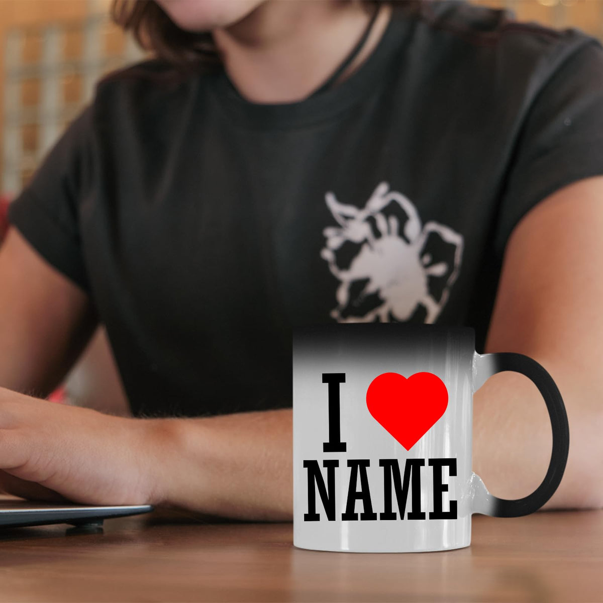 I love name magic mug on a desk in front of a woman in a black T-shirt