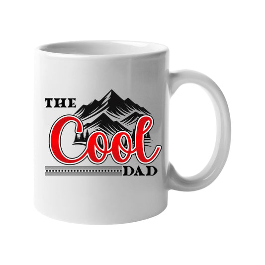 White mug with “The Cool Dad” in red script under black mountain peaks