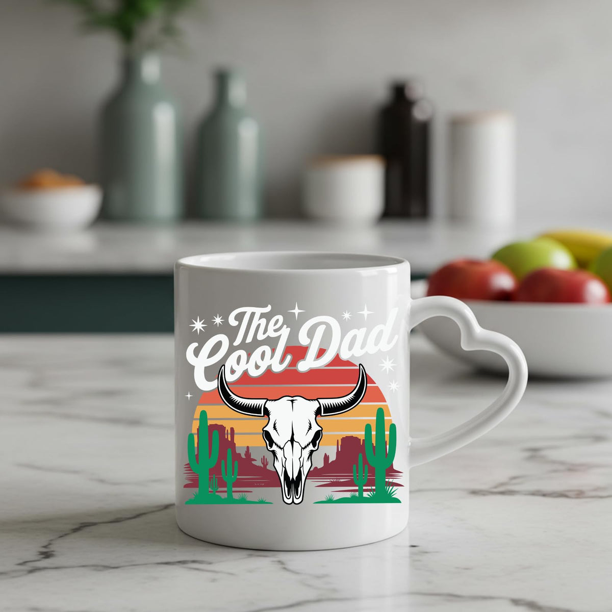 The Cool Dad bull skull heart-handle mug on a marble counter with fruit