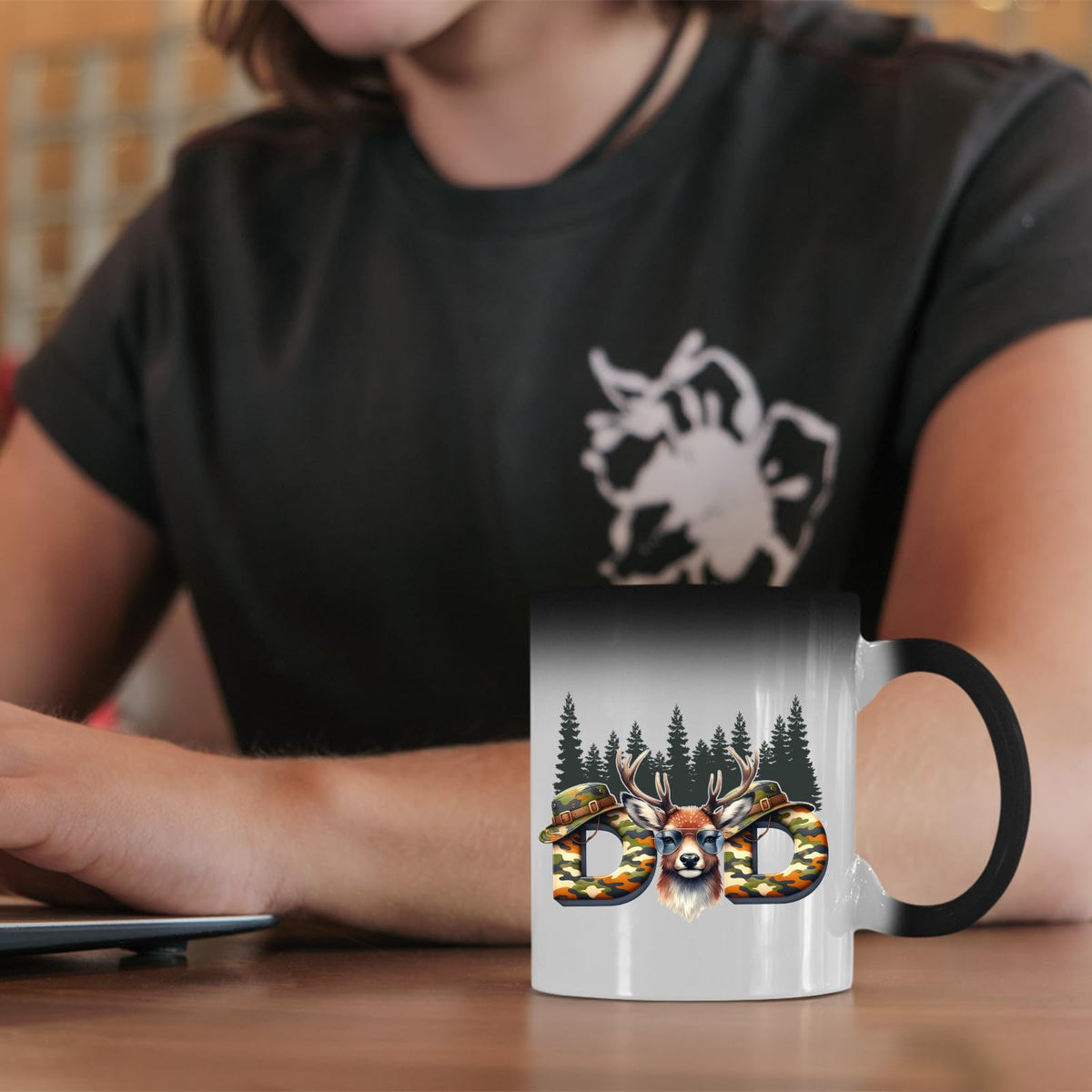 Hunting Dad deer colour changing mug on a desk beside a laptop