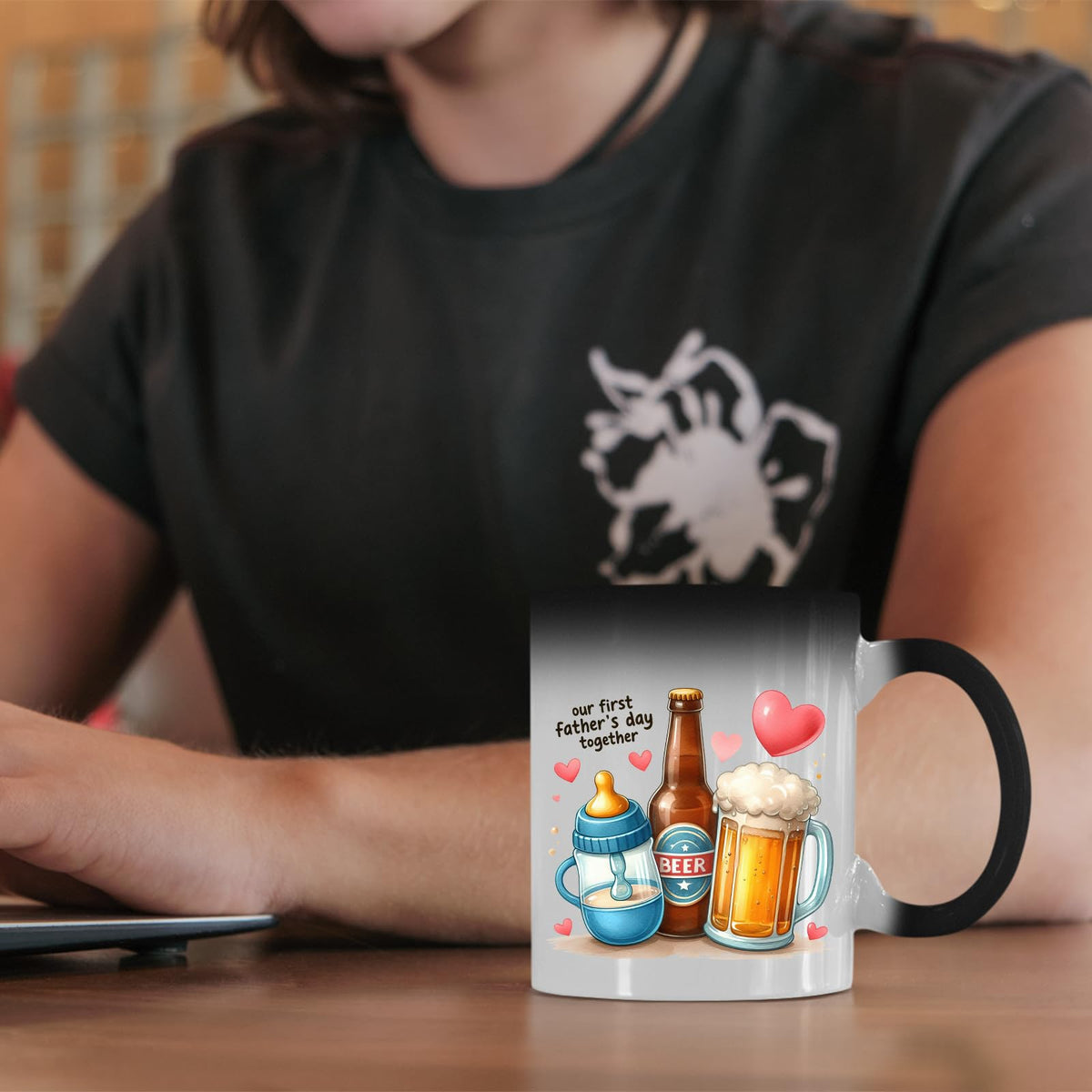 First Father’s Day hearts colour changing mug on a desk beside a laptop