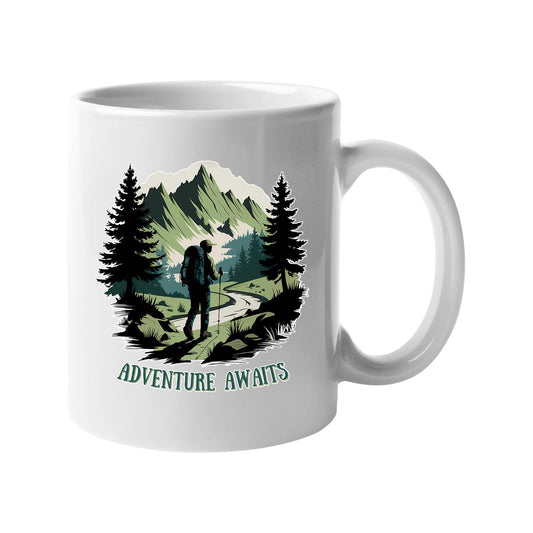 White mug with a hiker on a mountain trail between pine trees with “Adventure awaits”