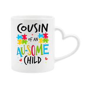 White heart-handle mug with “Cousin of an AU-SOME child” with colourful puzzle pieces