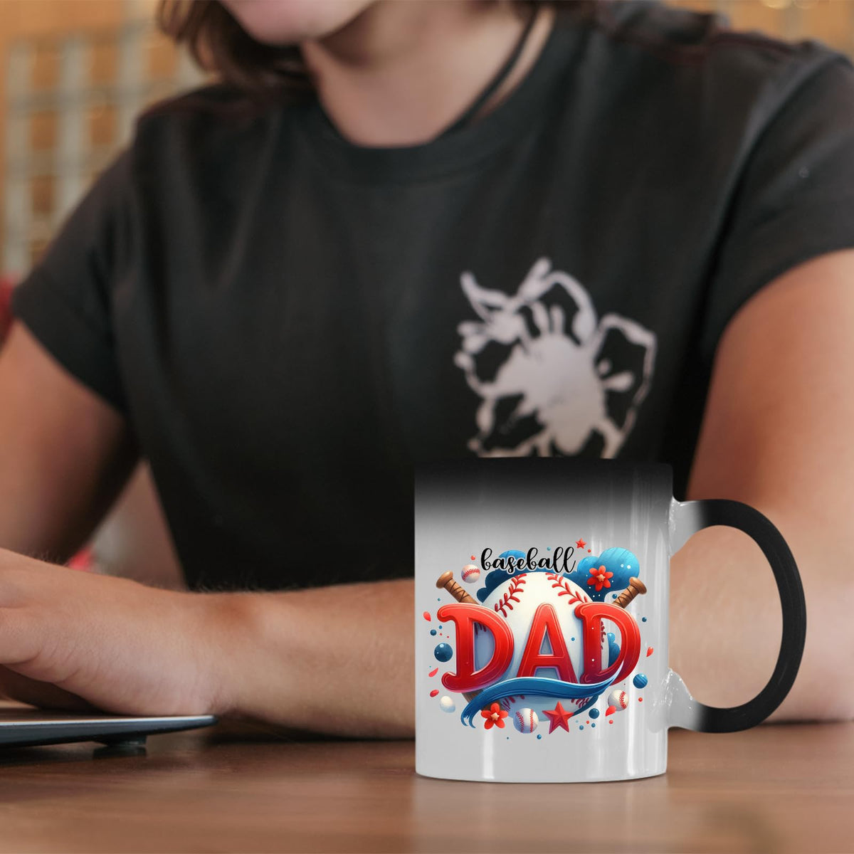 Baseball Dad colour changing mug on a desk beside a laptop