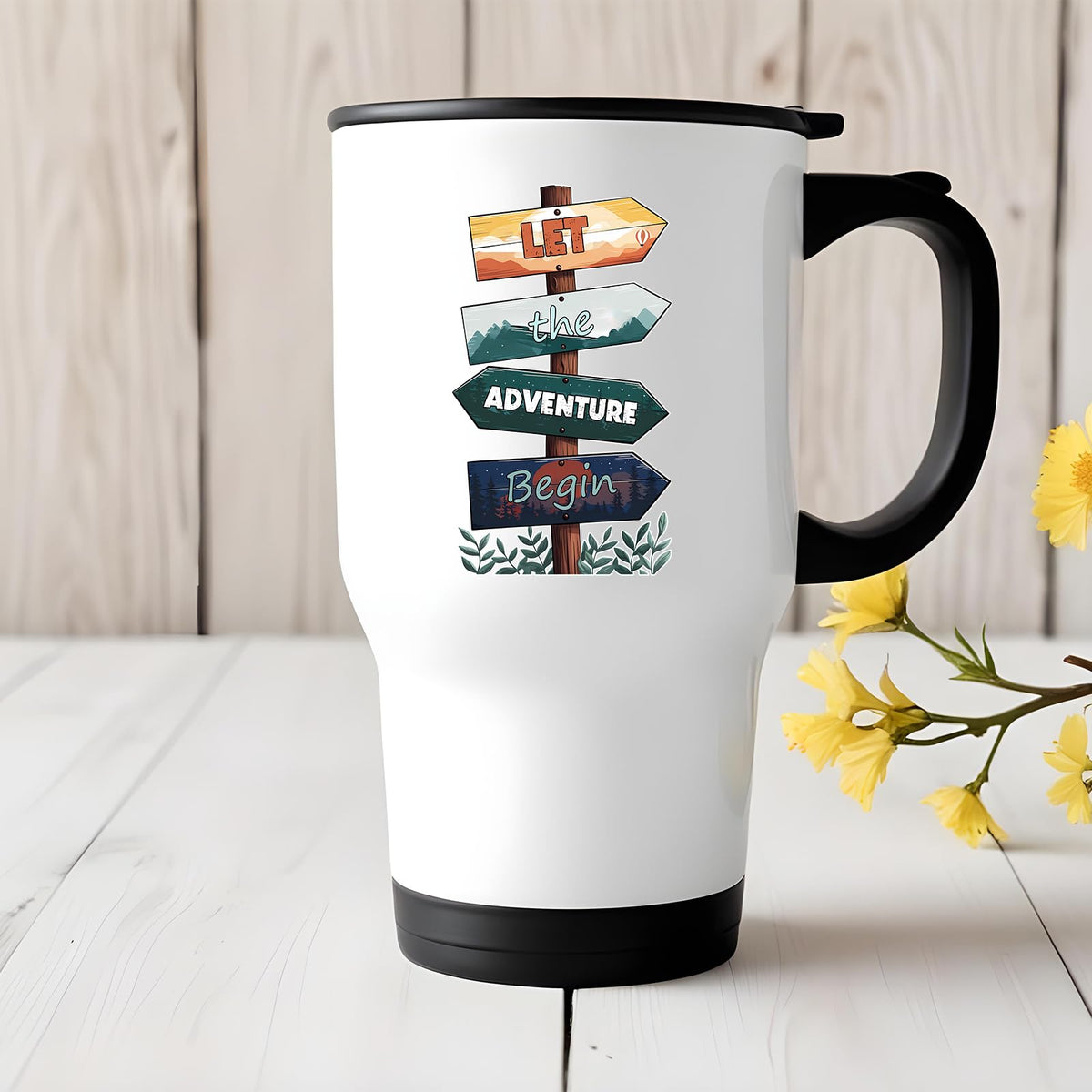 Let the Adventure Begin travel mug on a white wooden table with yellow flowers