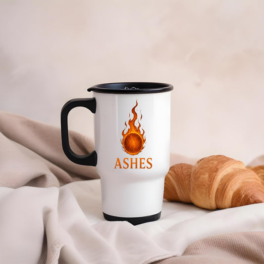 Ashes travel mug on linen beside a croissant