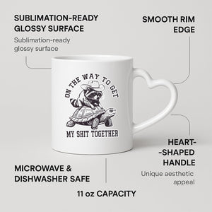raccoon and tortoise heart-handle mug on a marble counter with fruit