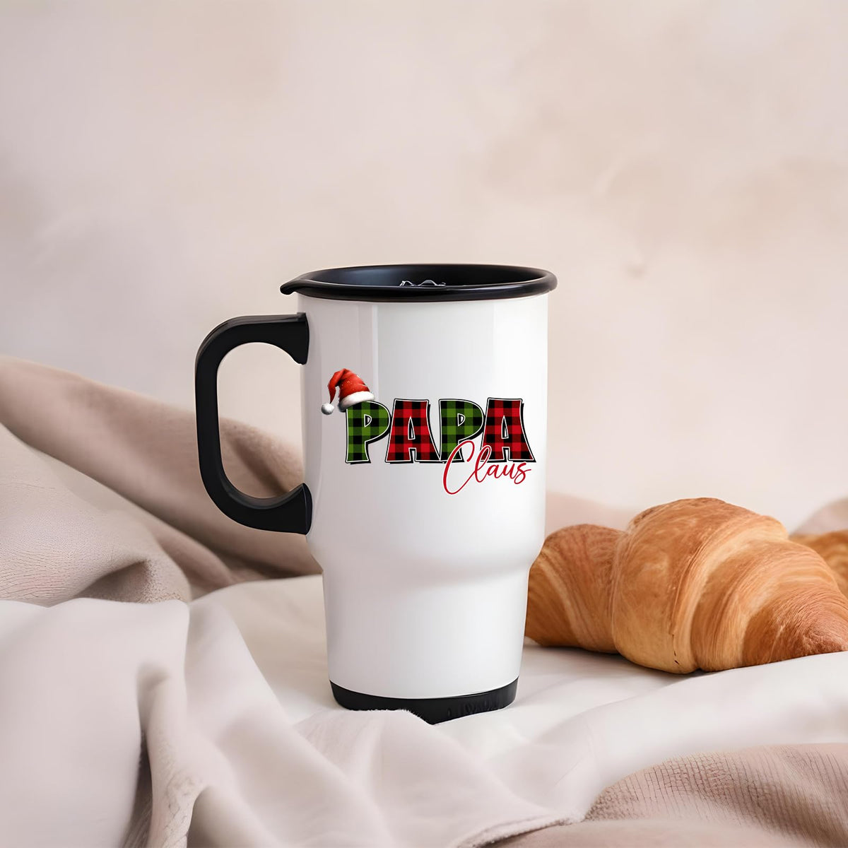 Papa Claus travel mug on a soft blanket beside a croissant