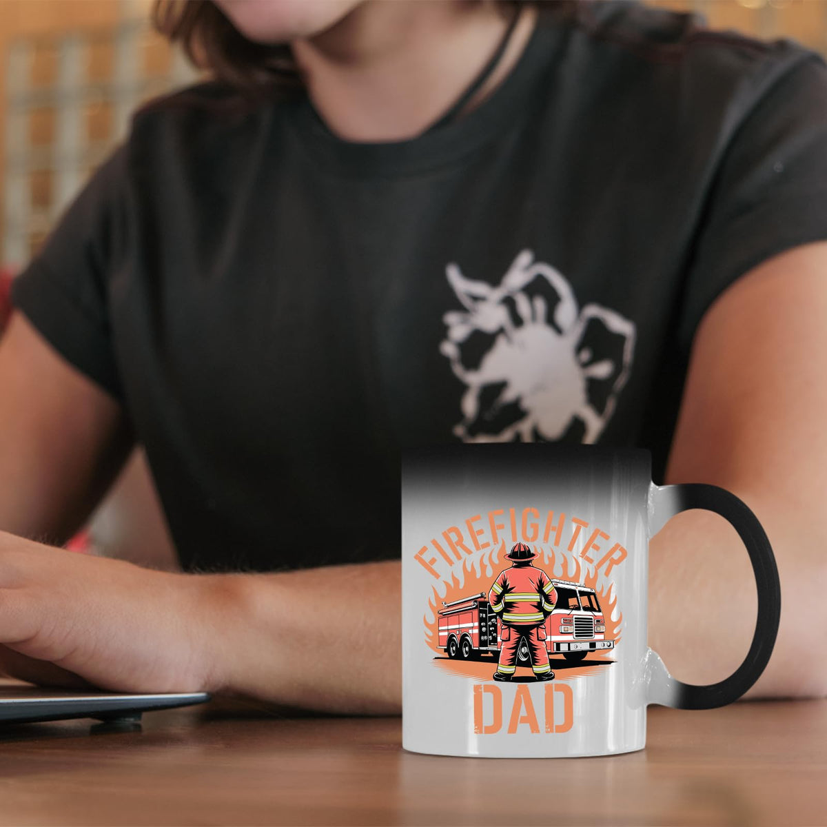 Firefighter Dad colour changing mug on a desk beside a laptop