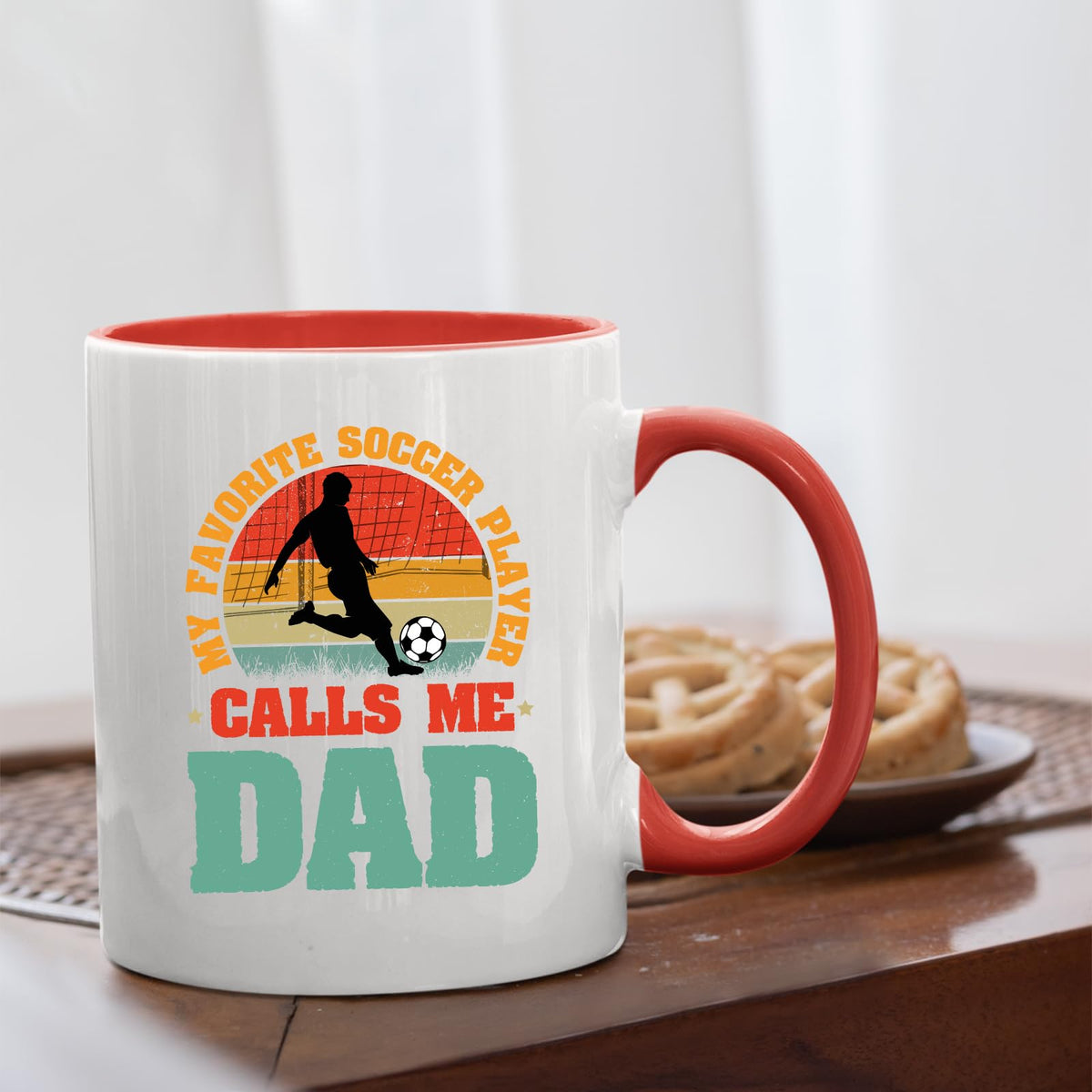 Soccer Dad mug with a red handle beside biscuits