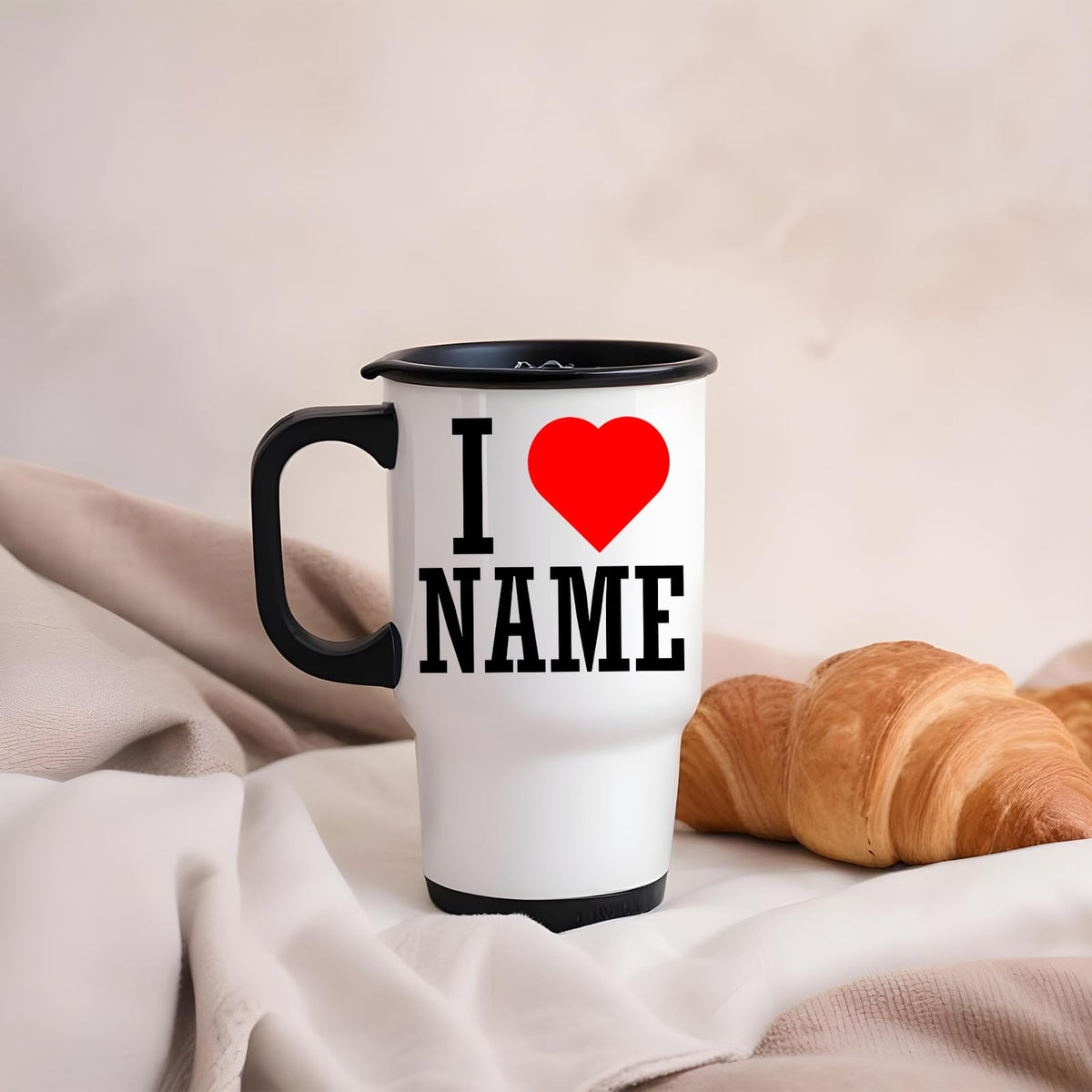 I love name travel mug on a blanket next to a croissant