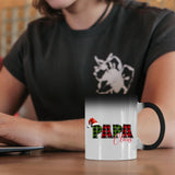 Papa Claus colour changing mug on a desk beside a laptop