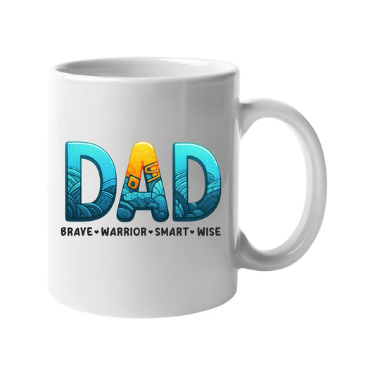 White mug with “DAD” in patterned blue and gold lettering above “brave · warrior · smart · wise”