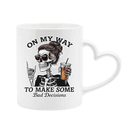 White heart-handle mug with a skeleton with sunglasses and an iced coffee and “On my way to make some bad decisions”
