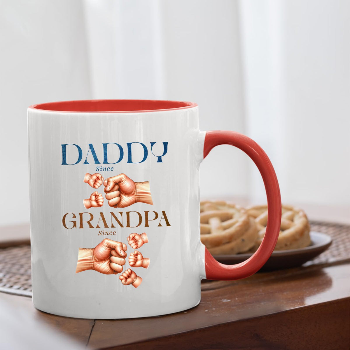 Daddy and Grandpa fist bump mug with a red handle beside biscuits