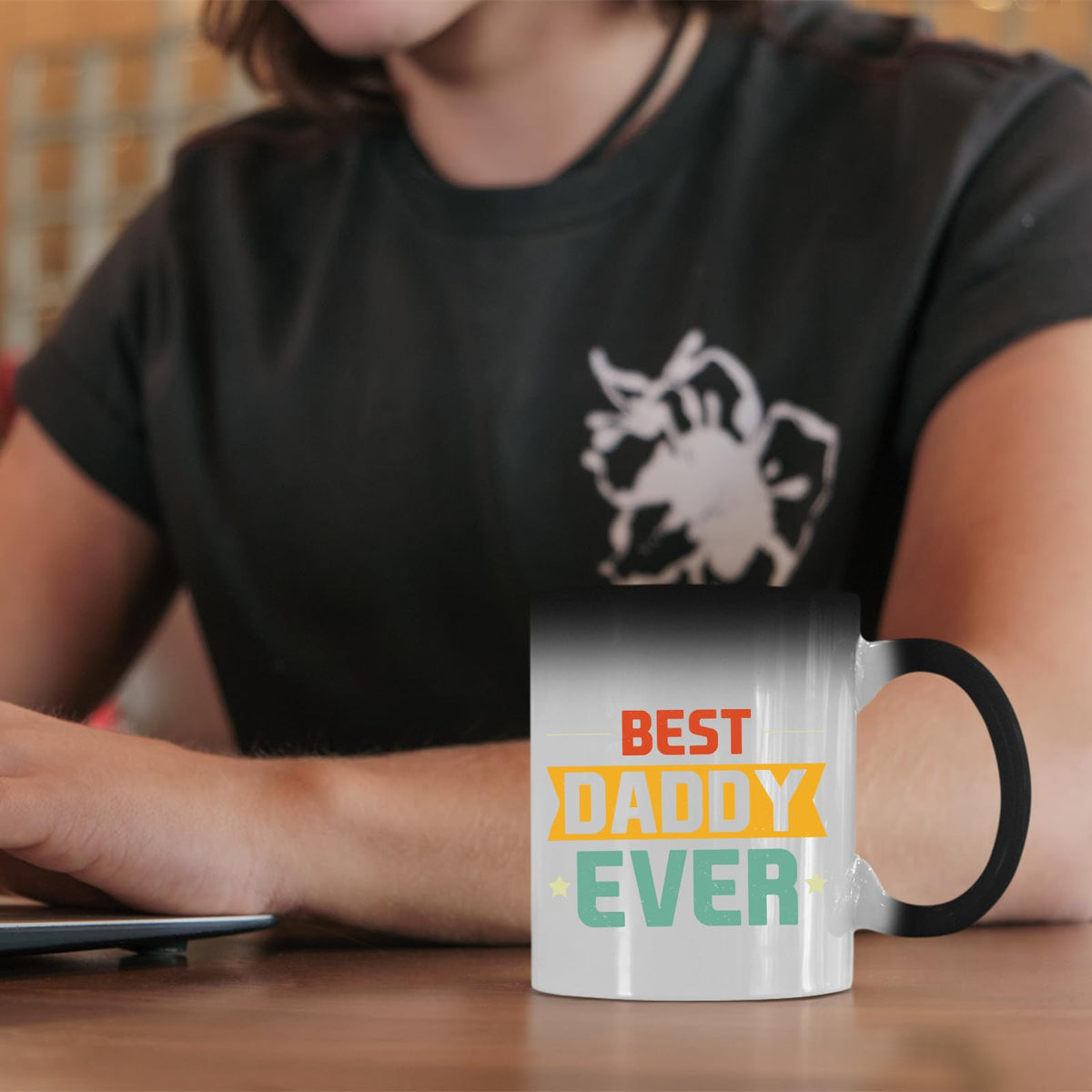 Best Daddy Ever retro colour changing mug on a desk beside a laptop