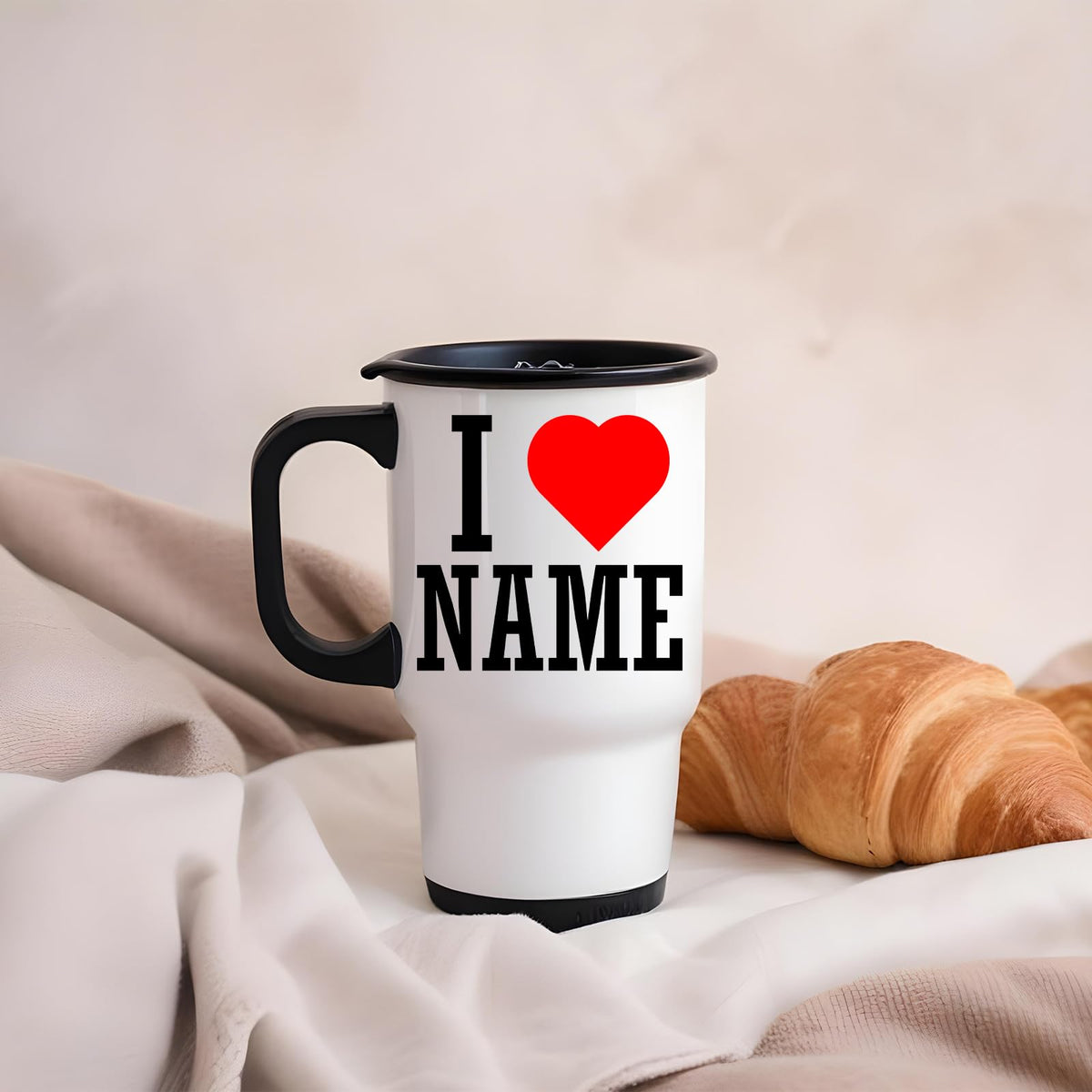 I love name travel mug with a croissant on a pink blanket