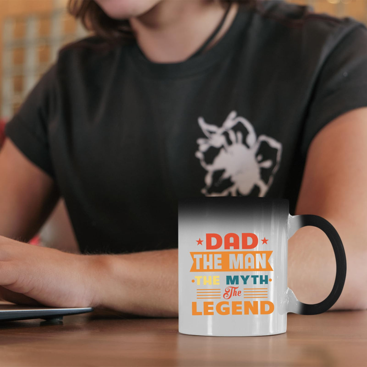 Dad the Man retro colour changing mug on a desk beside a laptop