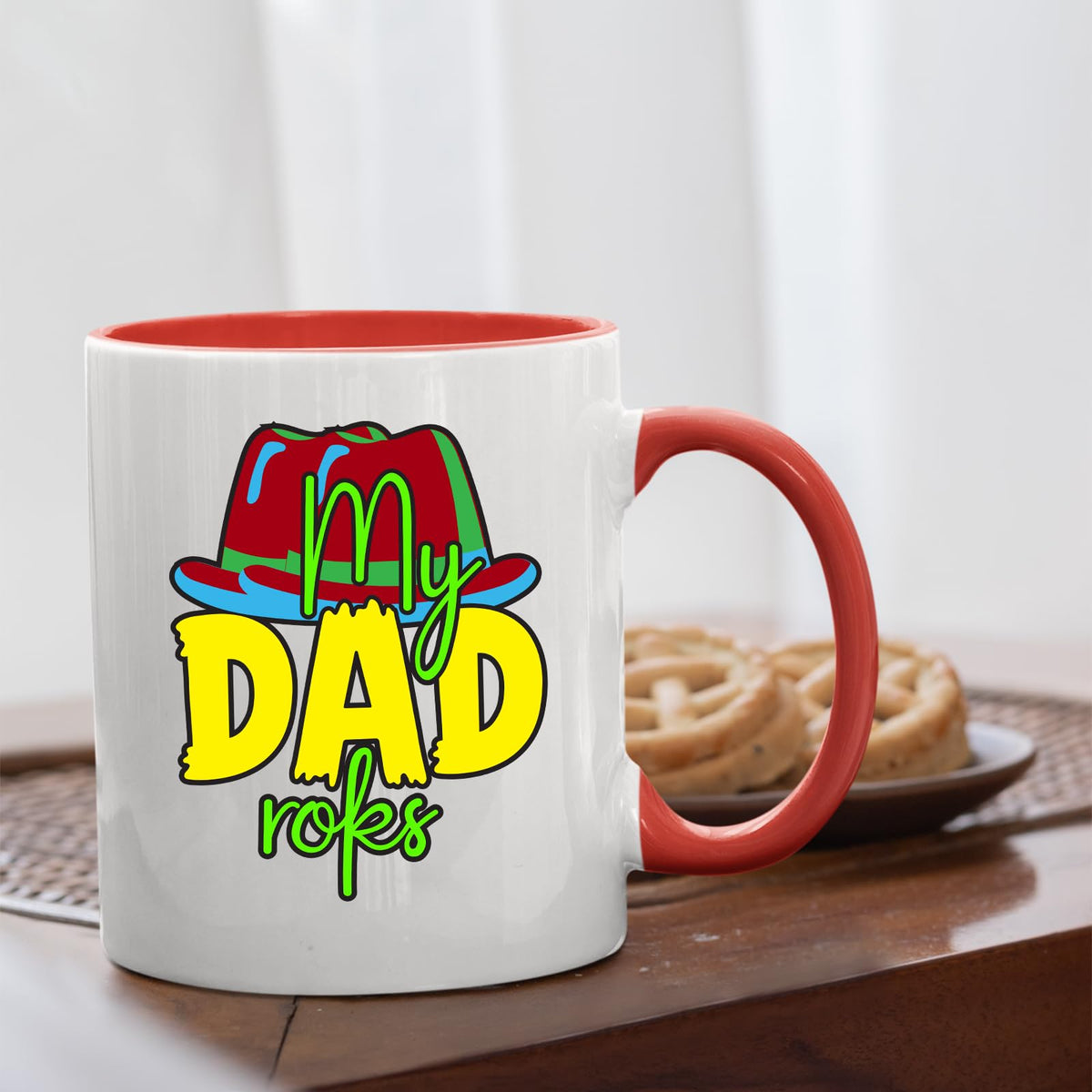 Red handle mug with the colourful My Dad Rocks hat design on a table