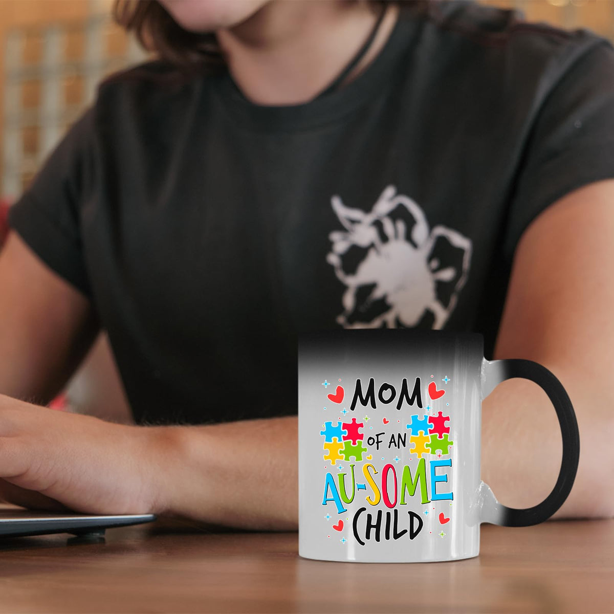 Mom of an Au-Some Child colour changing mug on a desk beside a laptop