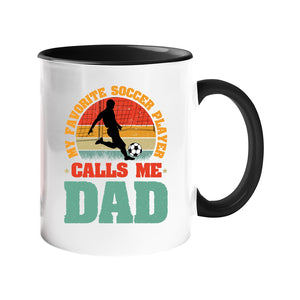 Colour handle mug with a footballer in silhouette on a retro sunset with “My favorite soccer player calls me Dad” – black handle and inside