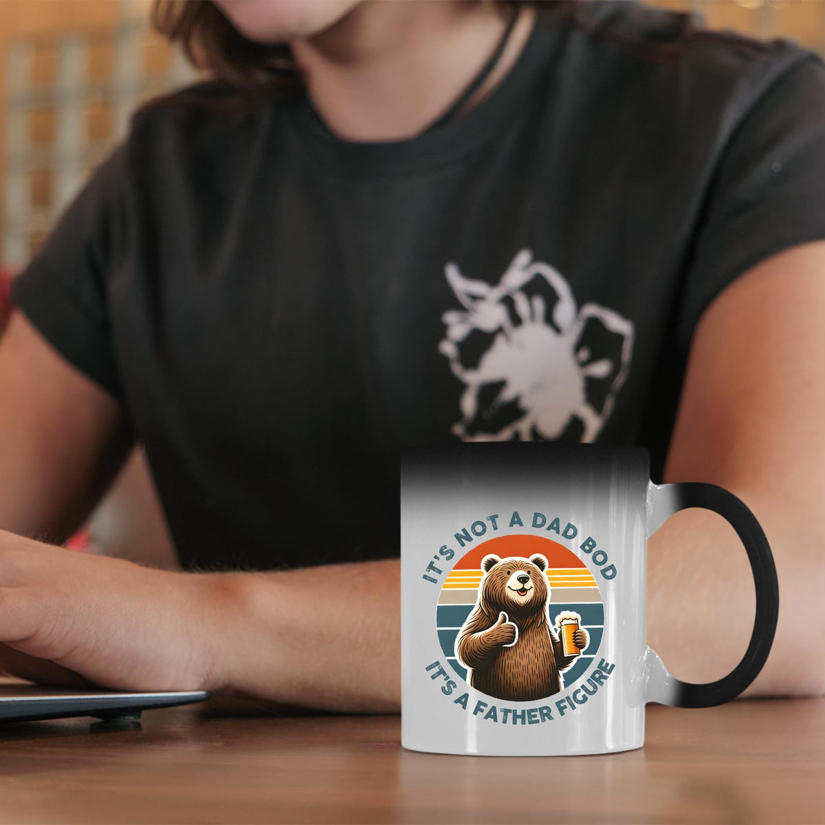 Dad Bod bear colour changing mug on a desk beside a laptop