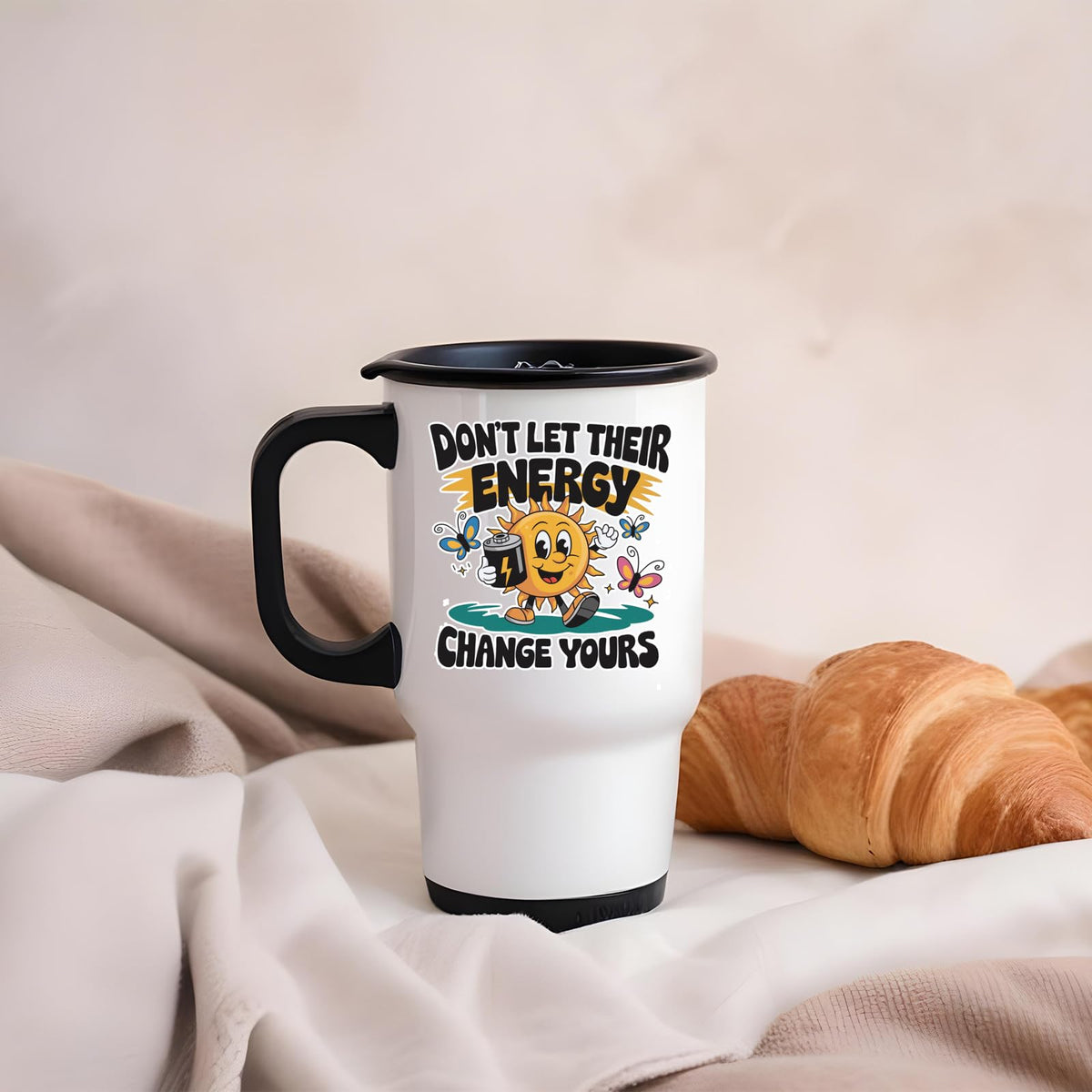 Positive Vibes sun travel mug on a soft blanket beside a croissant