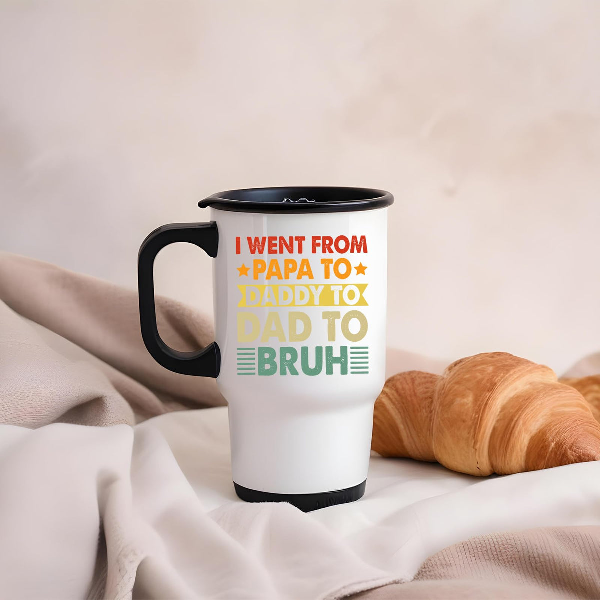 Papa to Bruh travel mug on a soft blanket beside a croissant