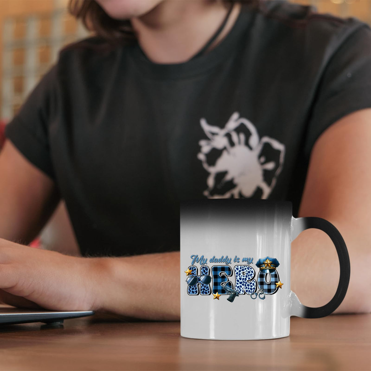 My Daddy Is My Hero police colour changing mug on a desk beside a laptop