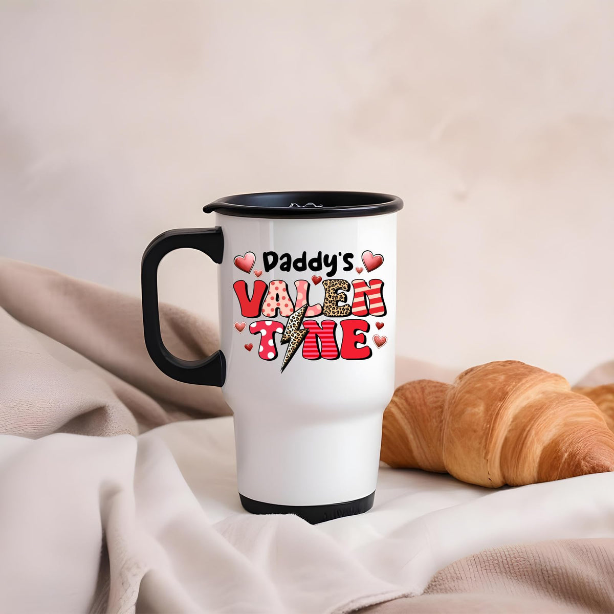 Daddy’s Valentine travel mug on a soft blanket beside a croissant
