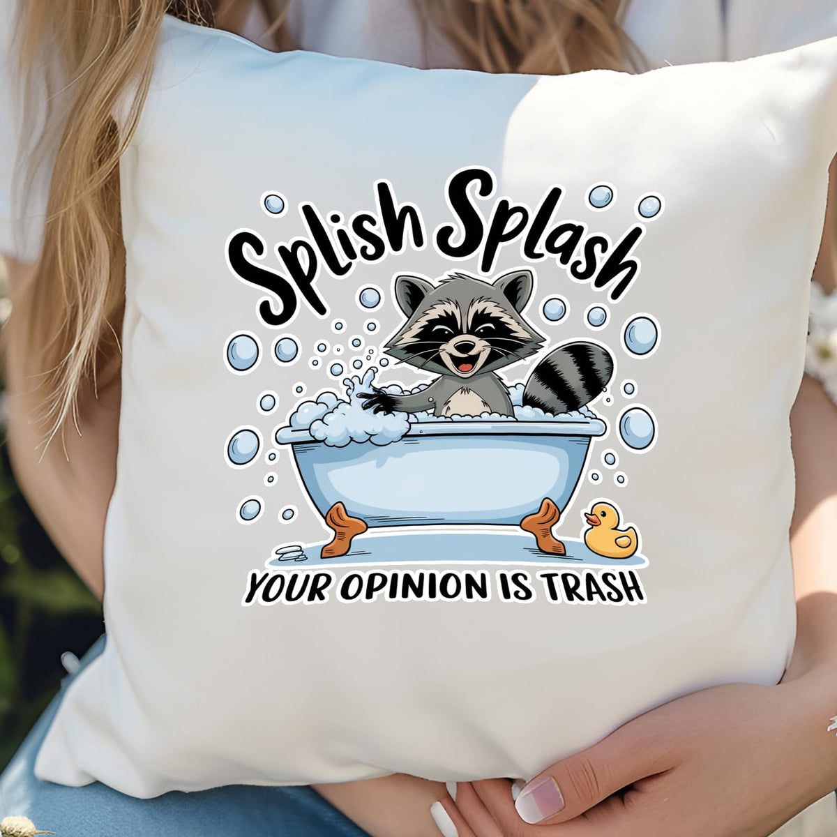 Hands holding the Splish Splash raccoon cushion