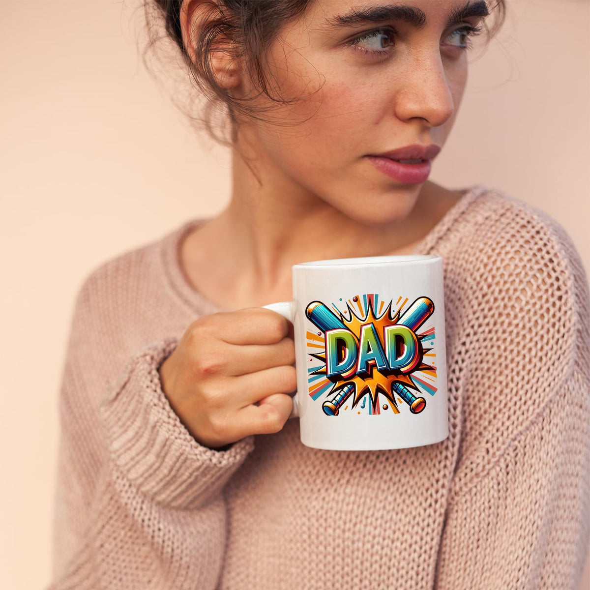 Woman in a pink jumper holding the DAD baseball bats mug