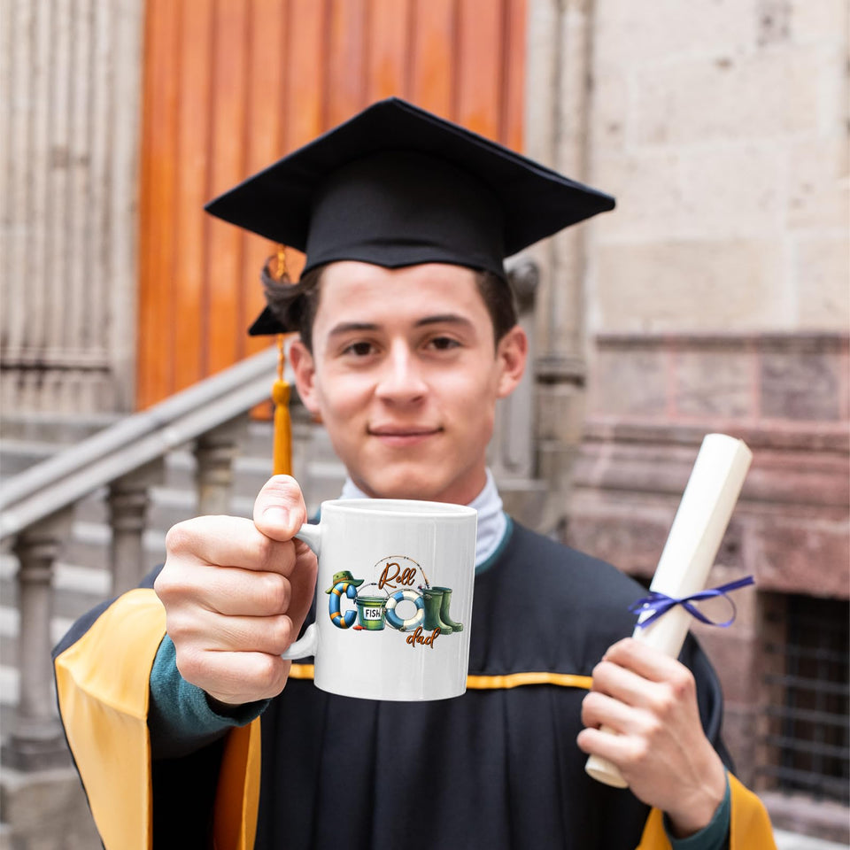 Graduate in cap and gown holding the Reel Cool Dad mug