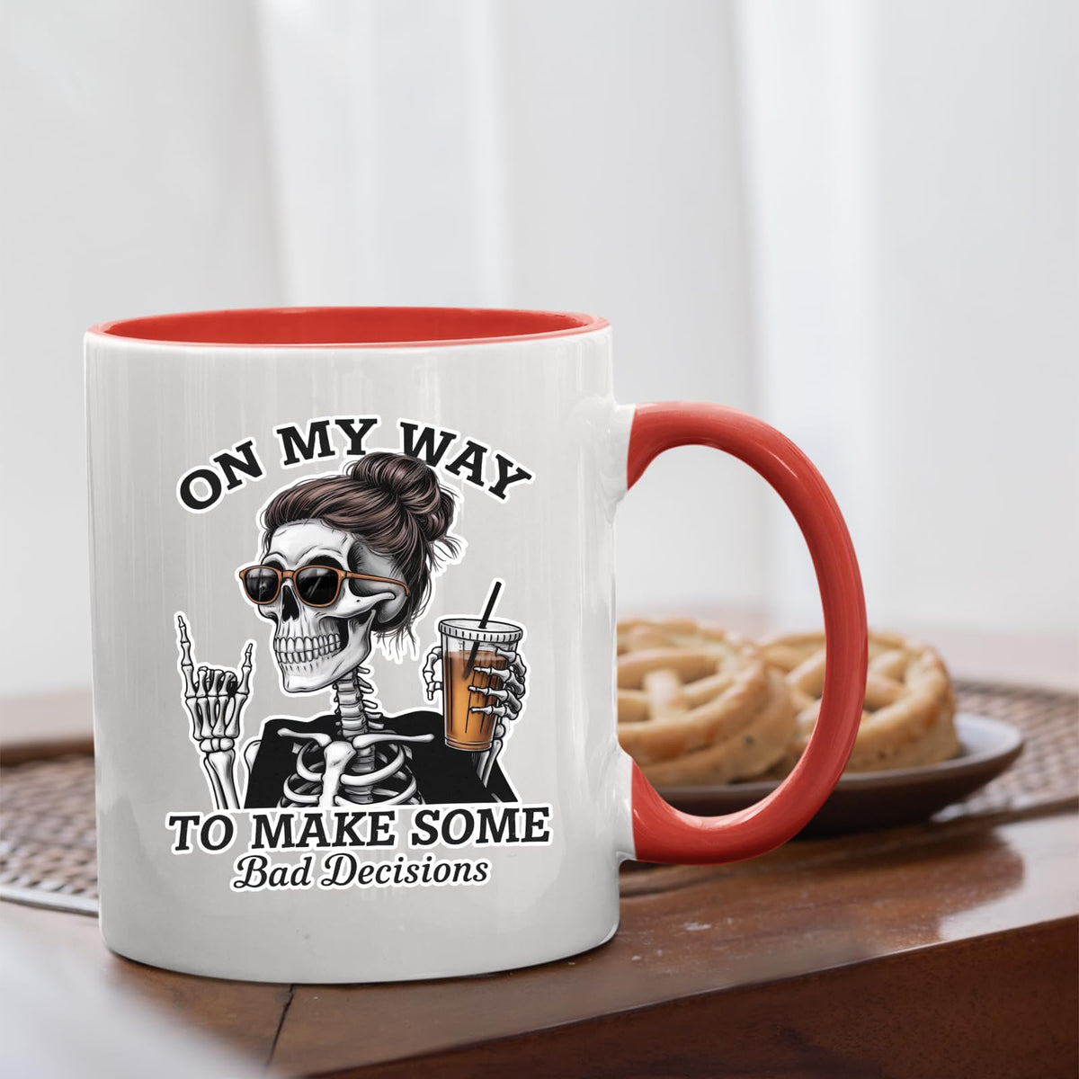 Bad Decisions skeleton mug with a red handle beside biscuits