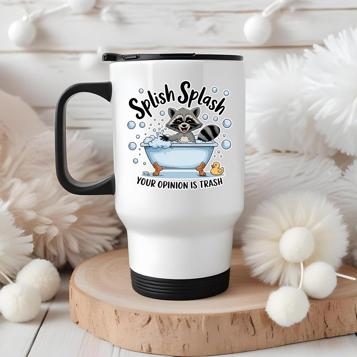 Splish Splash raccoon travel mug on a wooden slice with white pom-poms