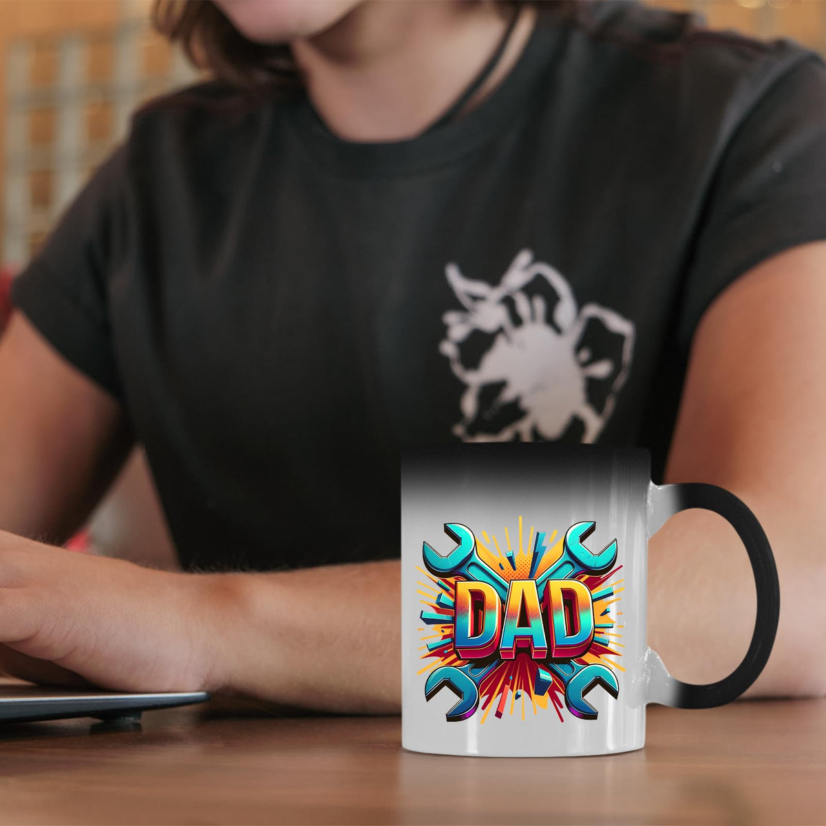 DAD spanners colour changing mug on a desk beside a laptop